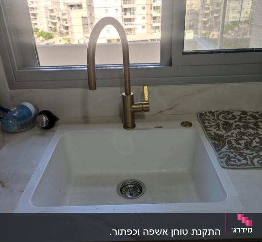 כיור עם ברז זהב במטבח מודרני